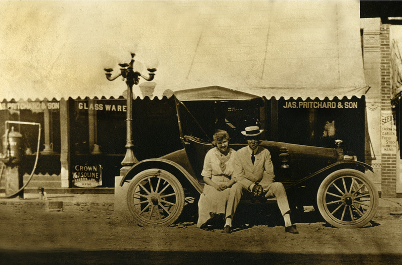 Captain  Pritchard's son Boud and his wife Lola Pauline Smith Pritchard (affectionately known as "Miss Lovie") sitting in front of the hardware store. 